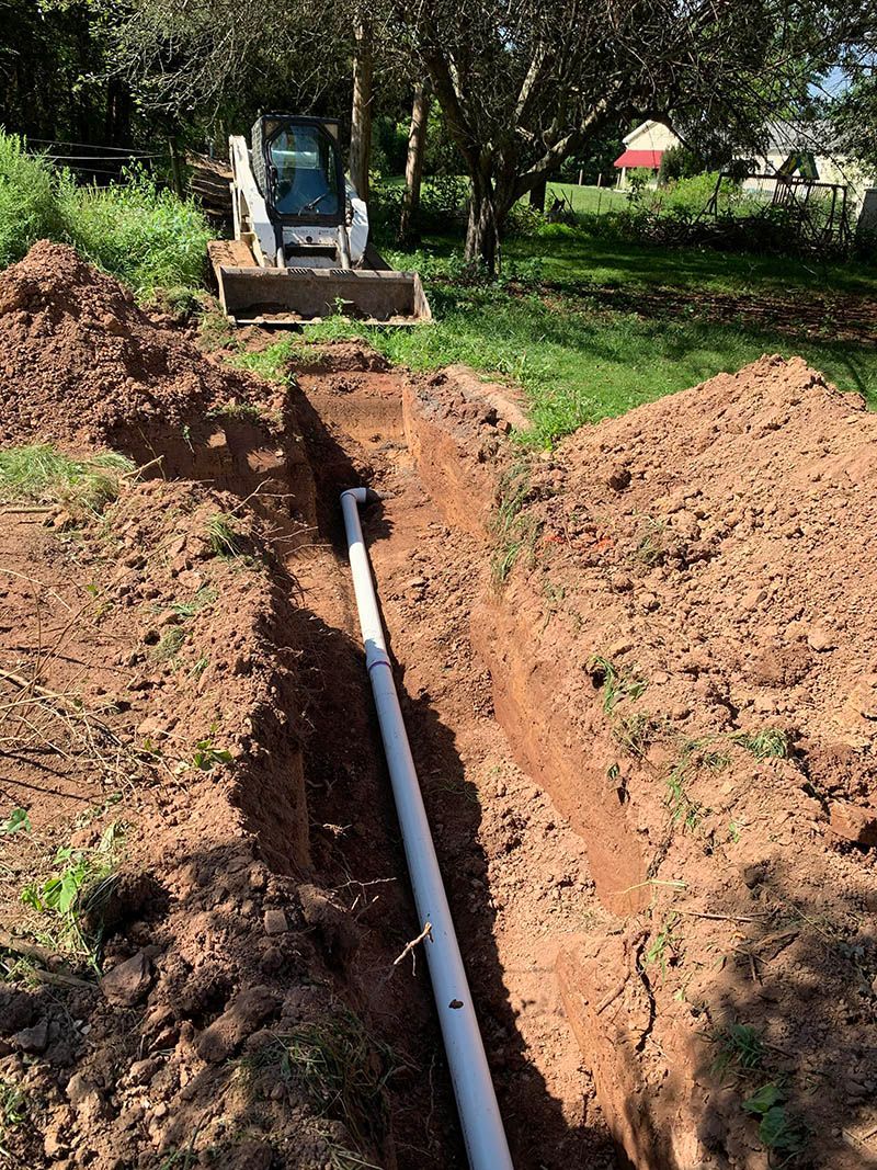A pipe is being installed in a hole in the ground.