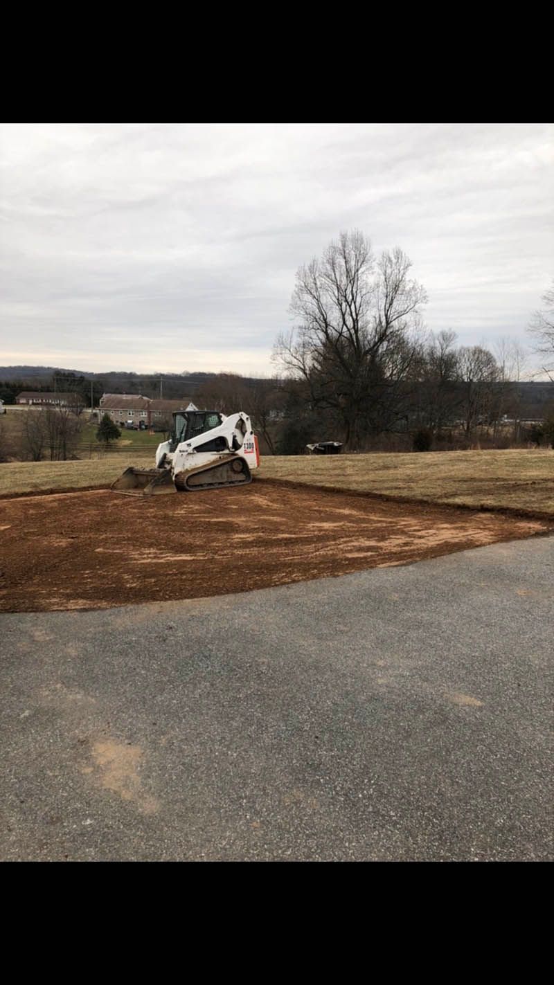 A bulldozer is moving dirt in a parking lot.