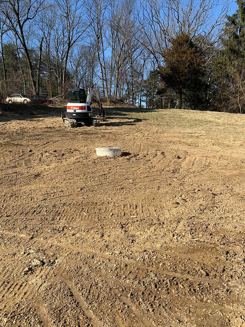 A bulldozer is sitting in the middle of a dirt field.