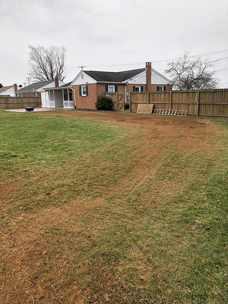A large grassy field with a house in the background.
