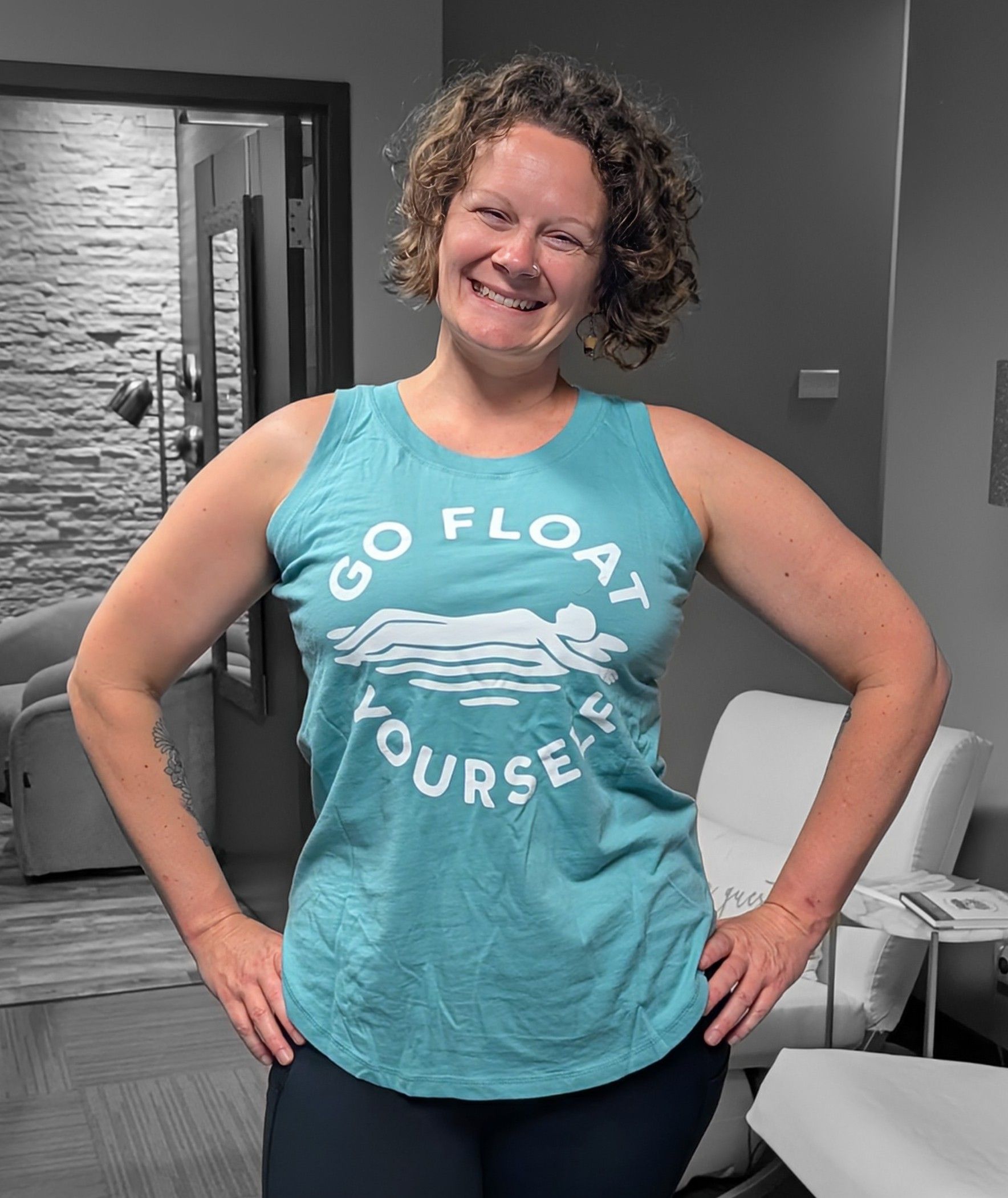 A woman is wearing a blue tank top that says go float yourself.