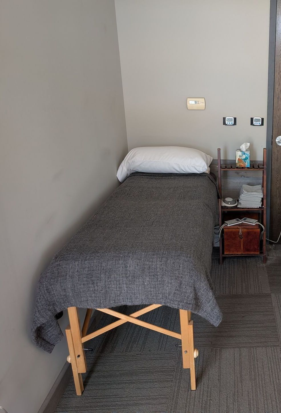 Two massage tables are in a room next to a door.