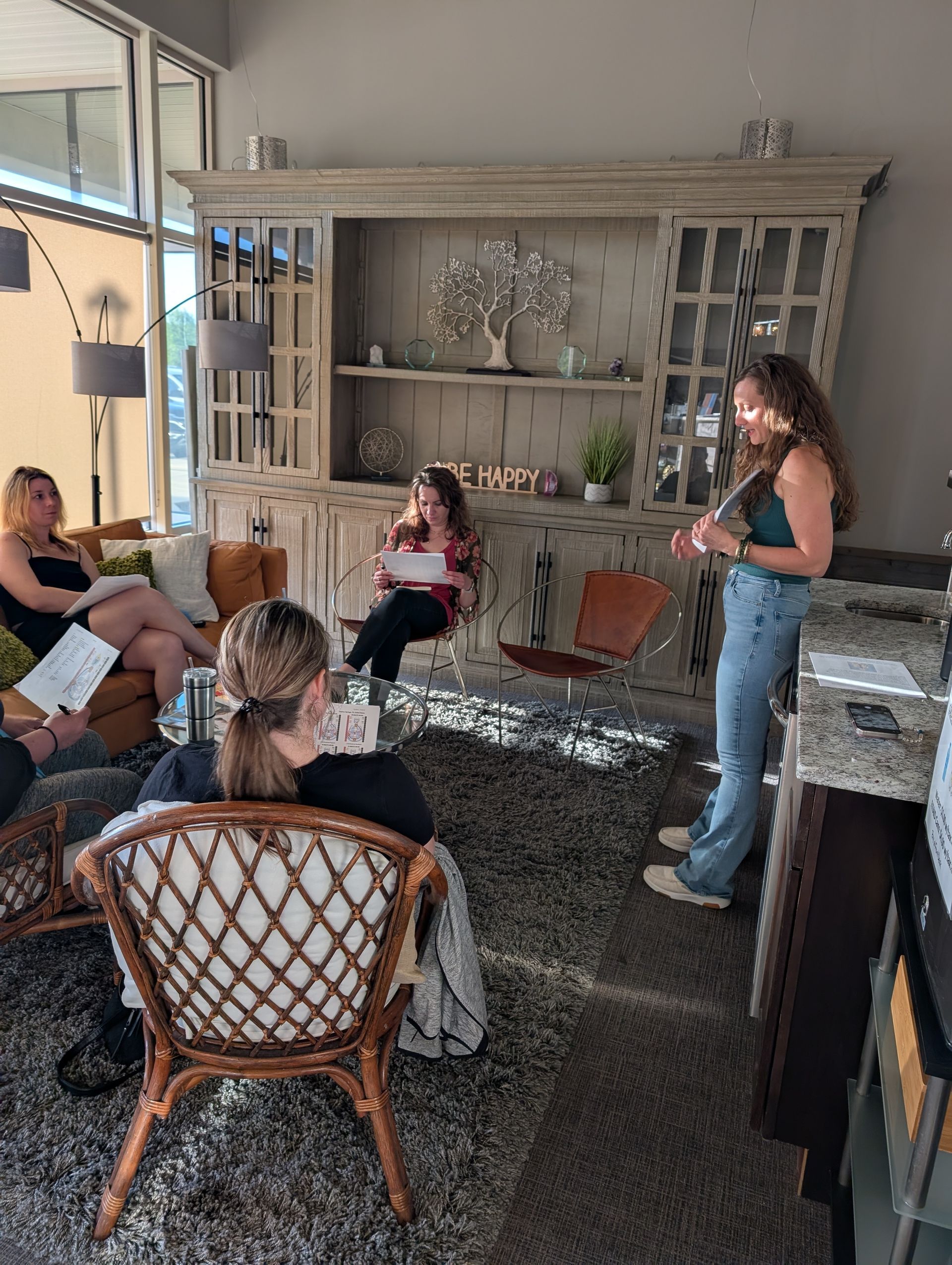 A group of women are sitting around a table in a living room.