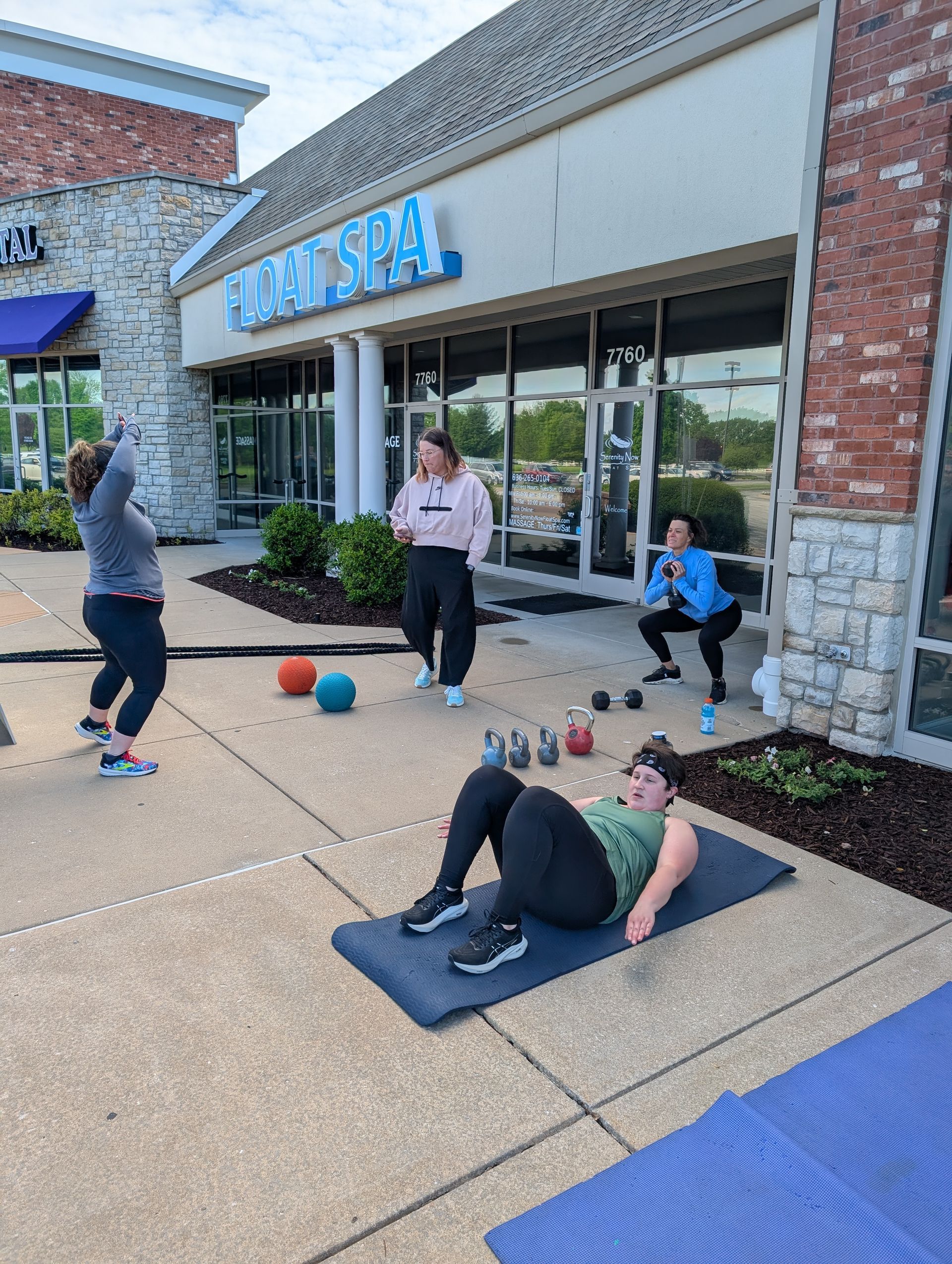 A group of women are doing exercises outside of a gym.