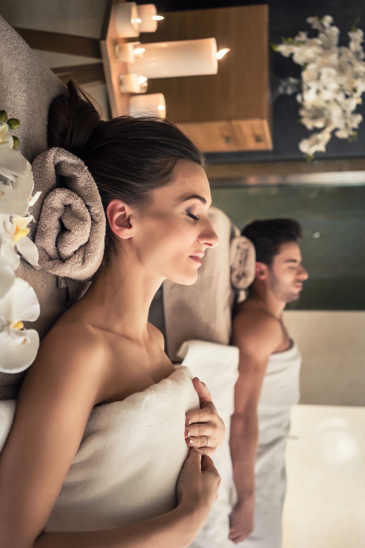 A man and a woman are wrapped in towels in a spa.