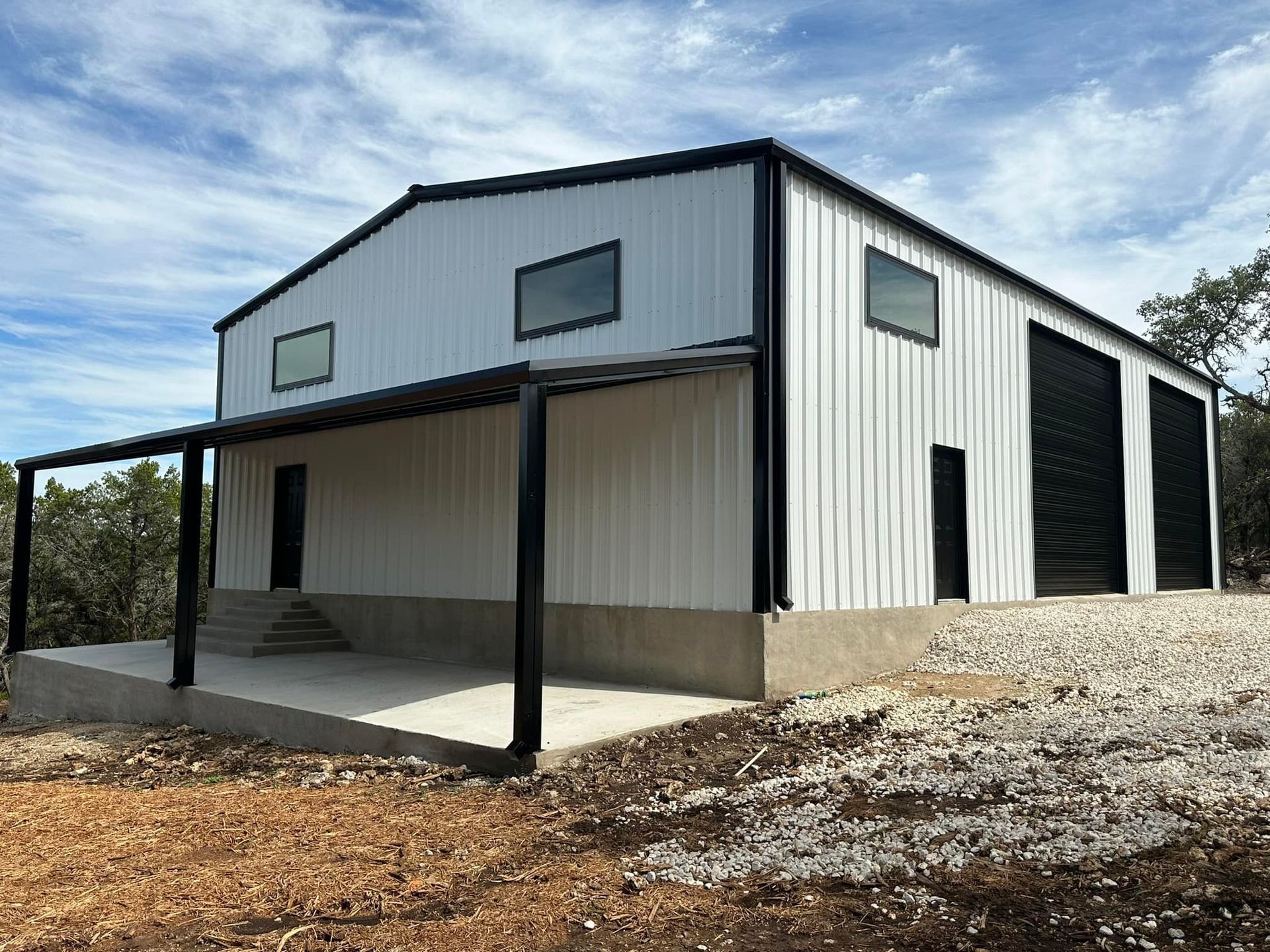 Woman in straw hat smiles, holding wine glass near a lake.