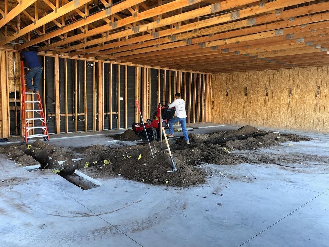 Construction site: Workers inside a partially built structure, excavating the concrete floor.