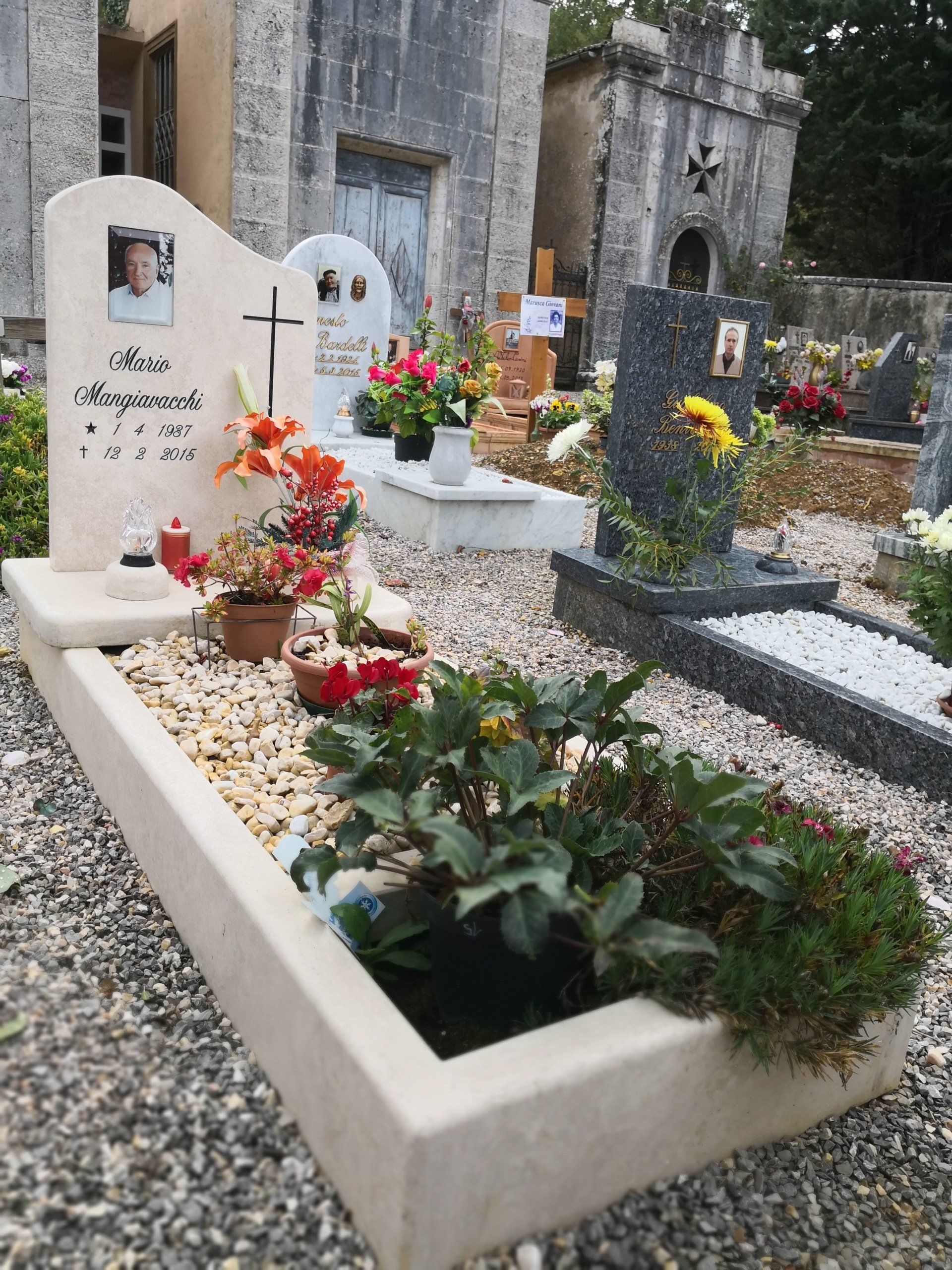 Una tomba in un cimitero con fiori e candele