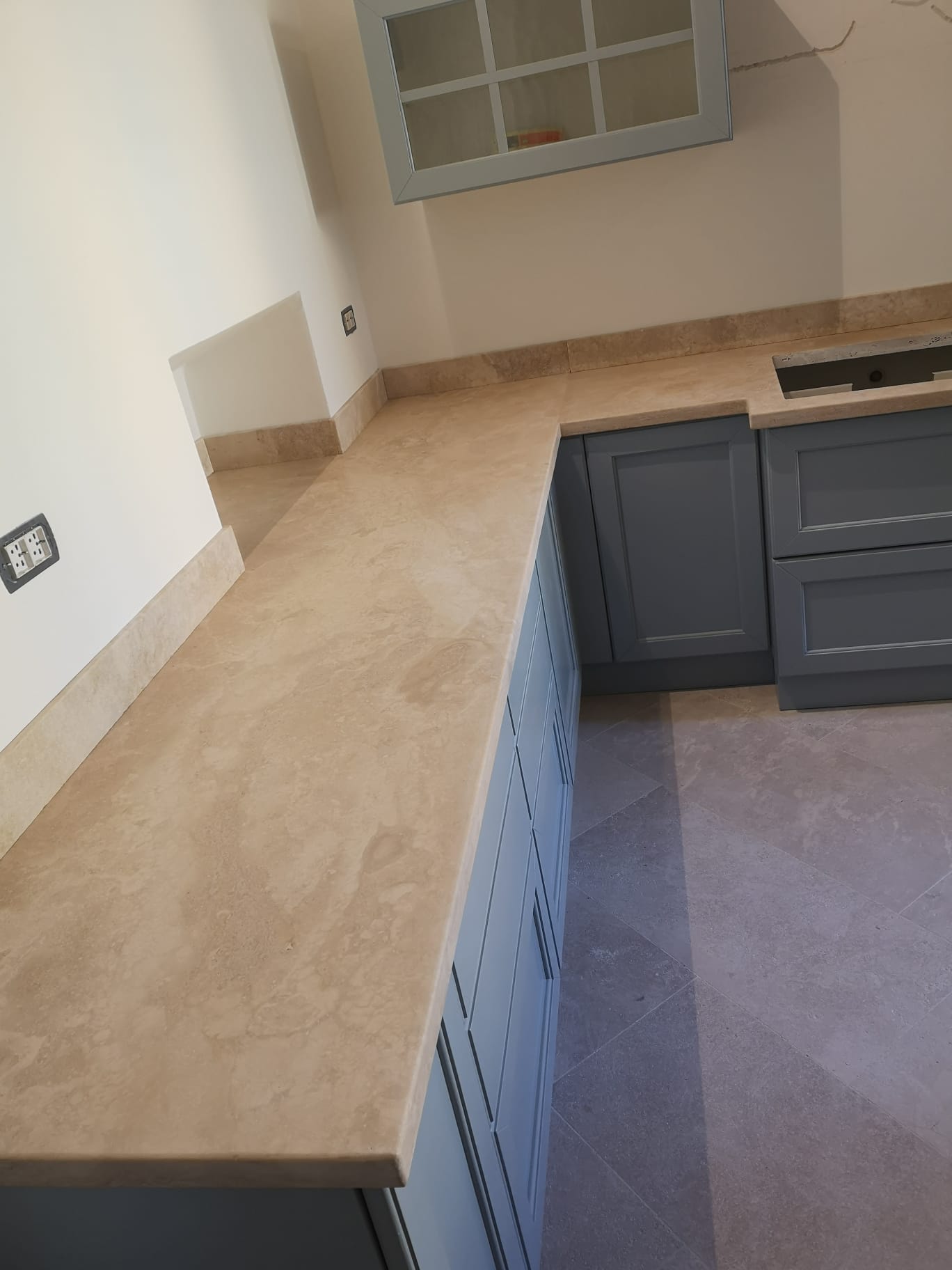 Una cucina con piano di lavoro in granito e mobili blu