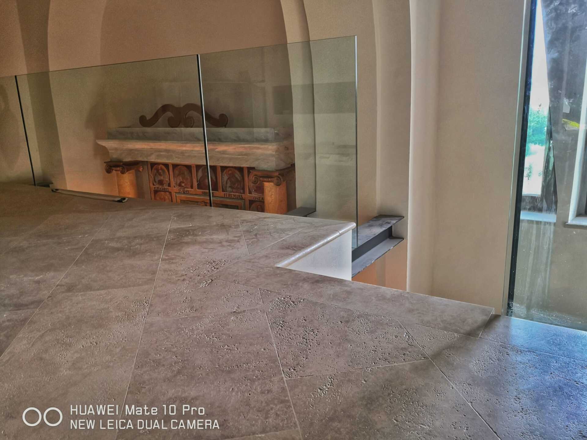 Una scala con ringhiera in vetro in un edificio.