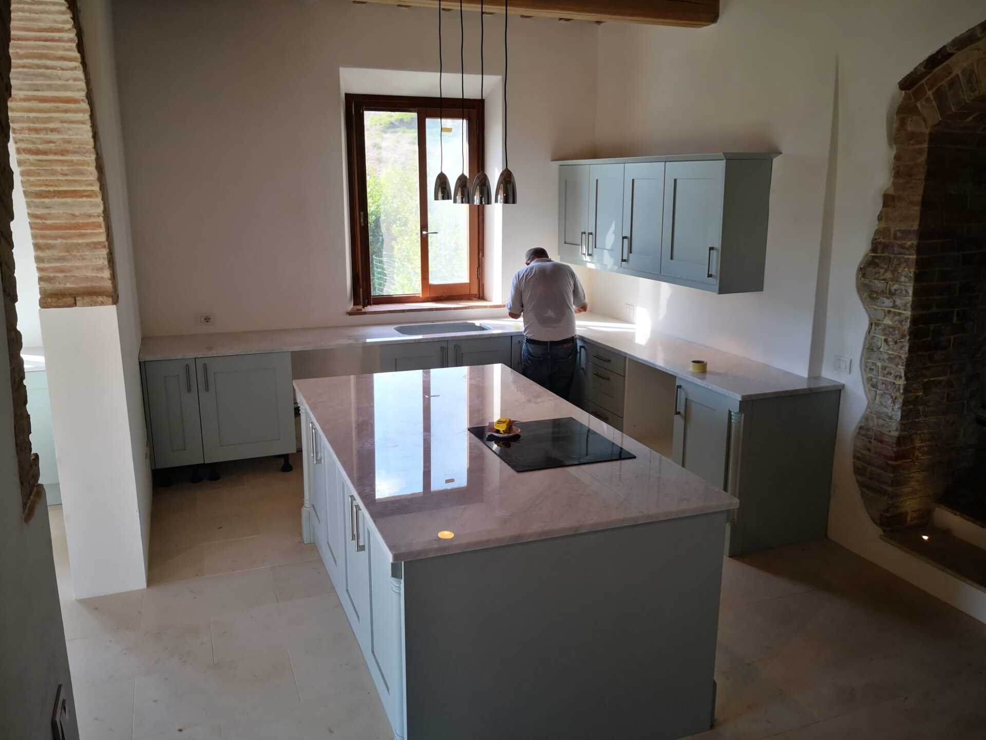 Un uomo sta lavorando in una cucina con una grande isola al centro