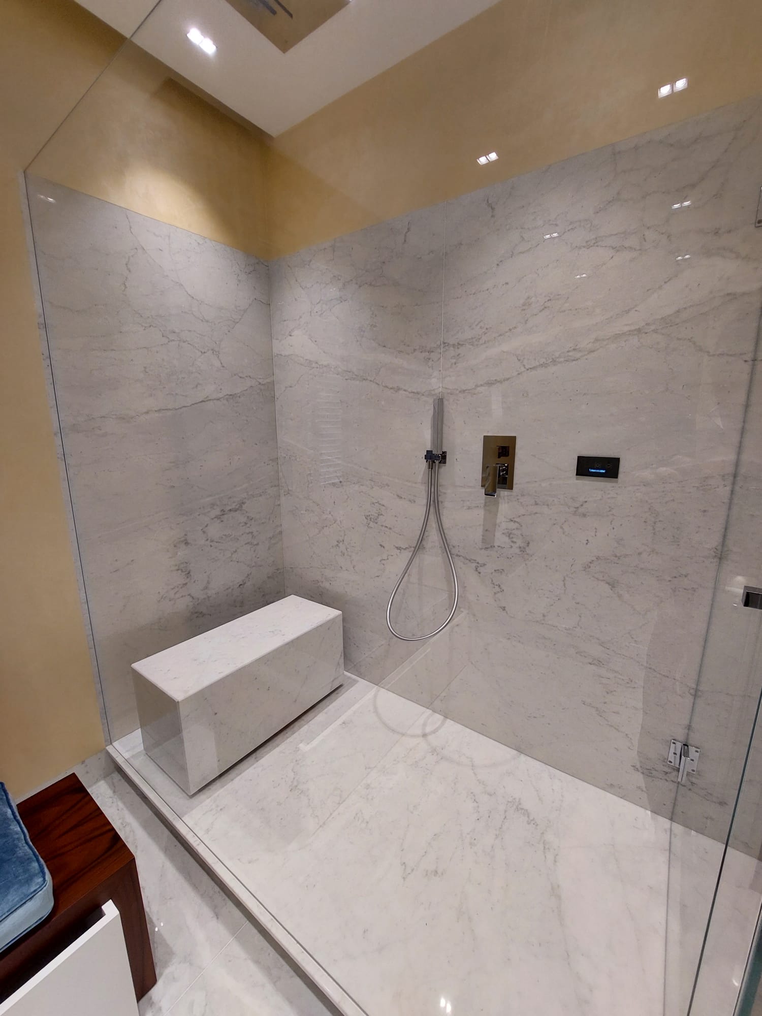 Un bagno con cabina doccia e panca