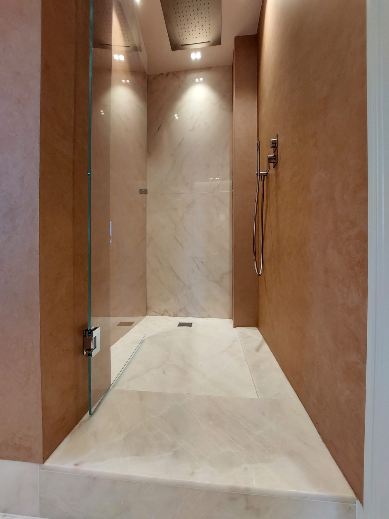 Un bagno con cabina doccia con porta in vetro