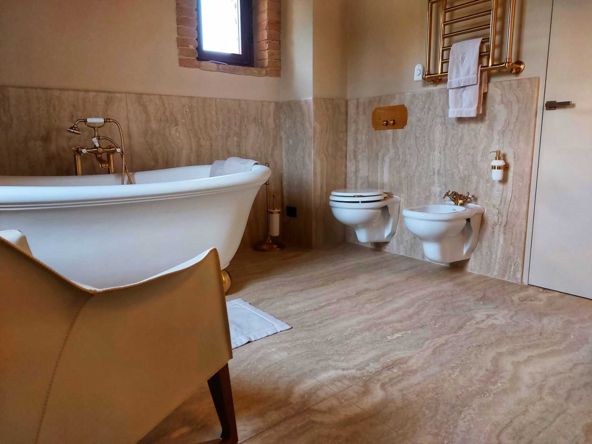 Un bagno con due WC e una vasca da bagno