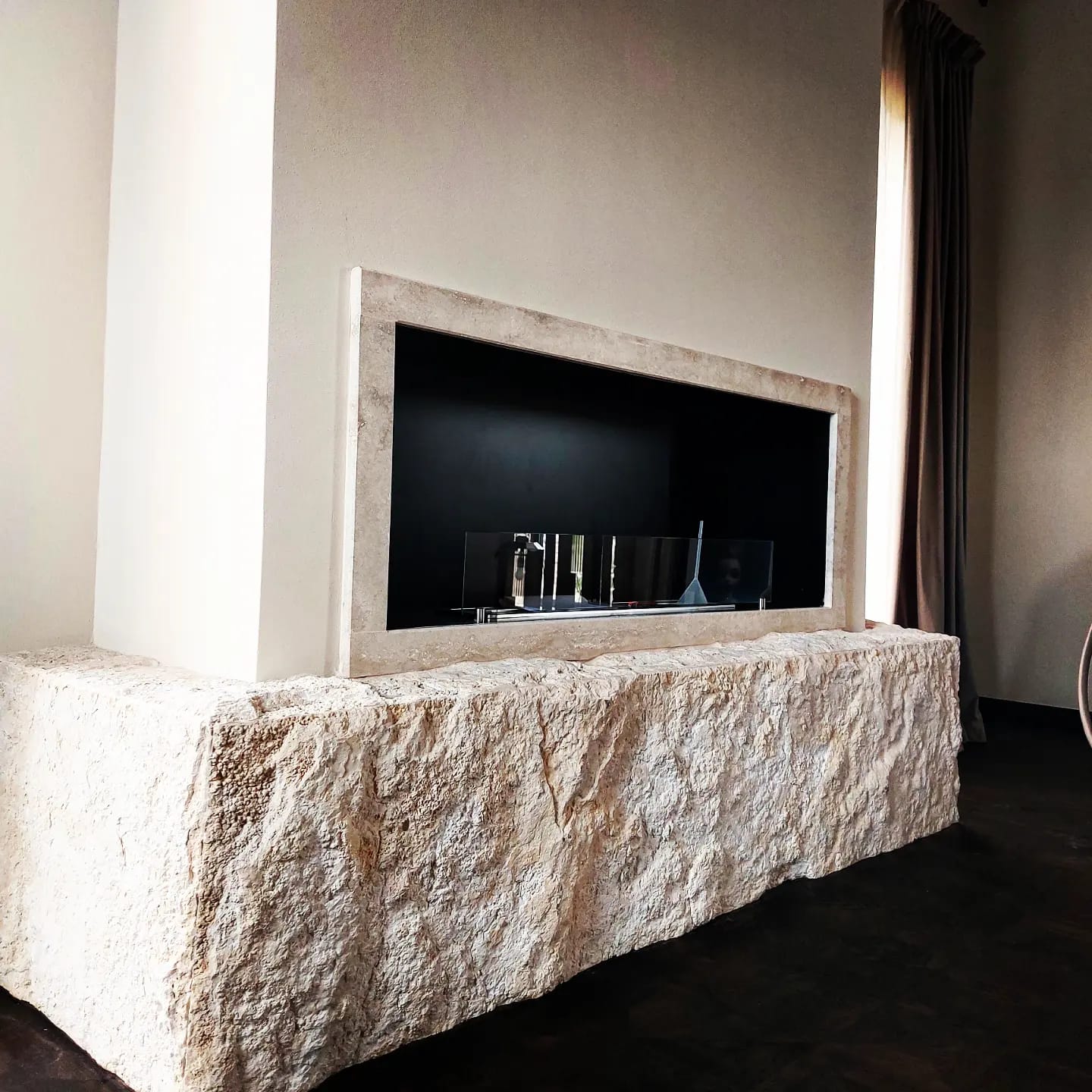 Un camino in una stanza con una cornice in pietra