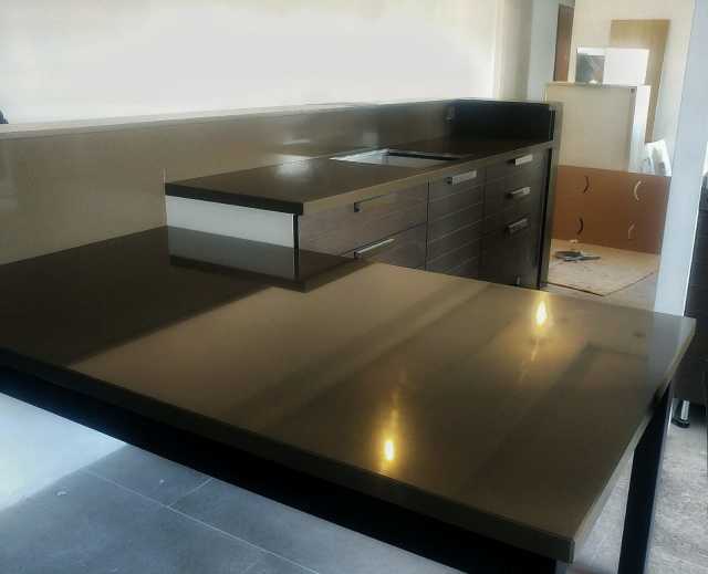 Una cucina con un piano di lavoro nero e mobili neri