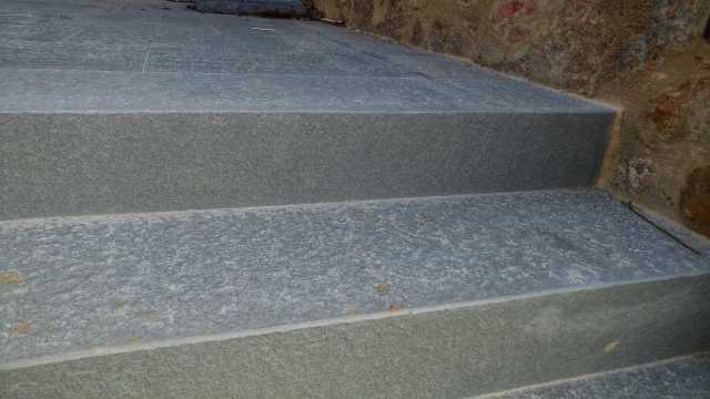 Un primo piano di una scalinata che porta a un muro di pietra.