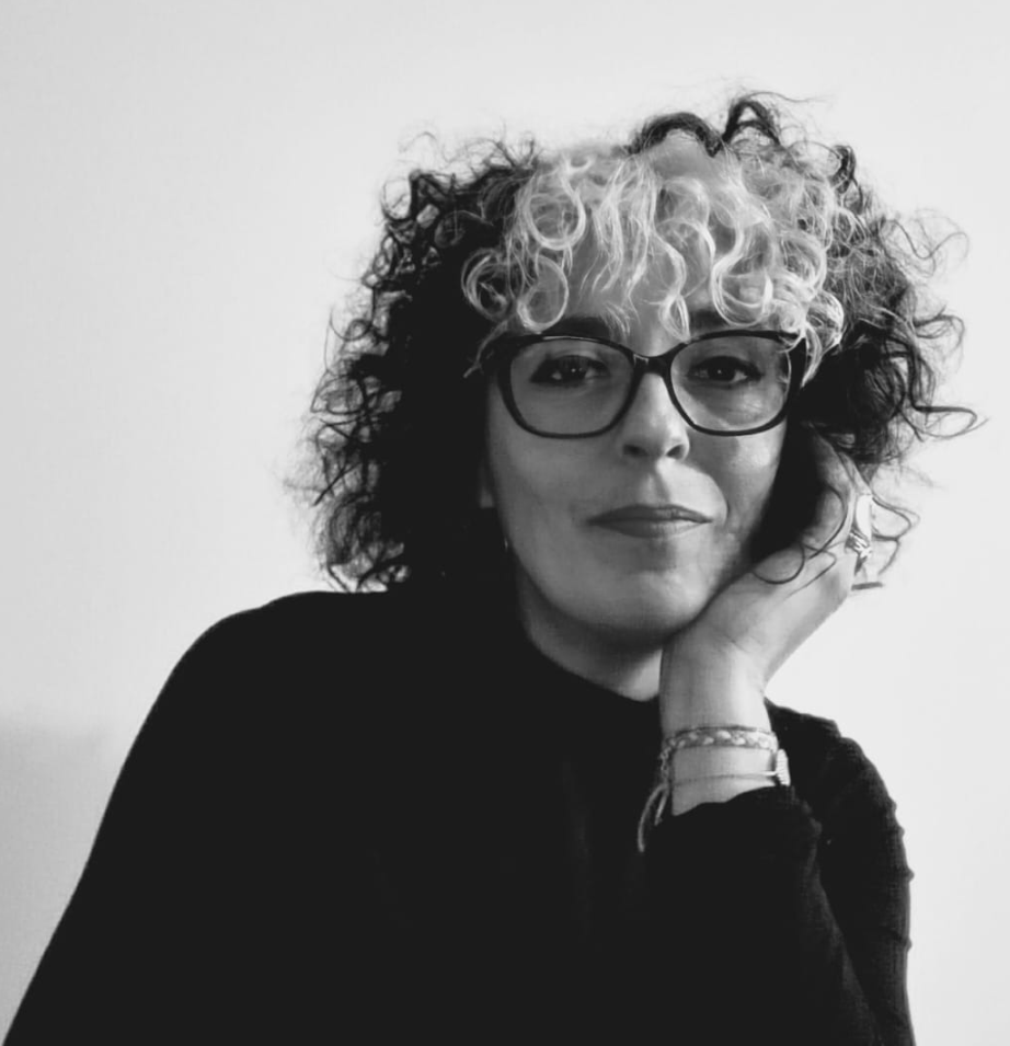 A black and white photo of a woman wearing glasses and curly hair.