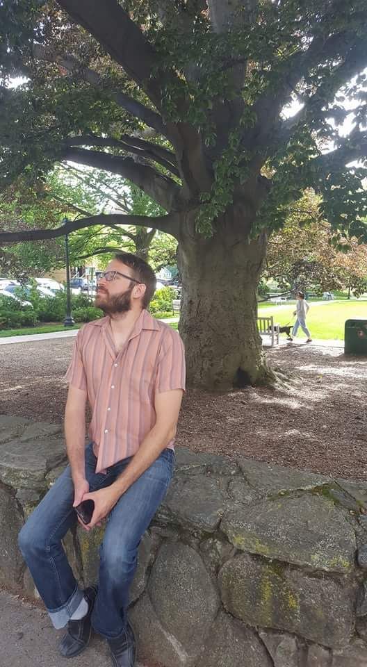 a poet is sitting under a tree in a park