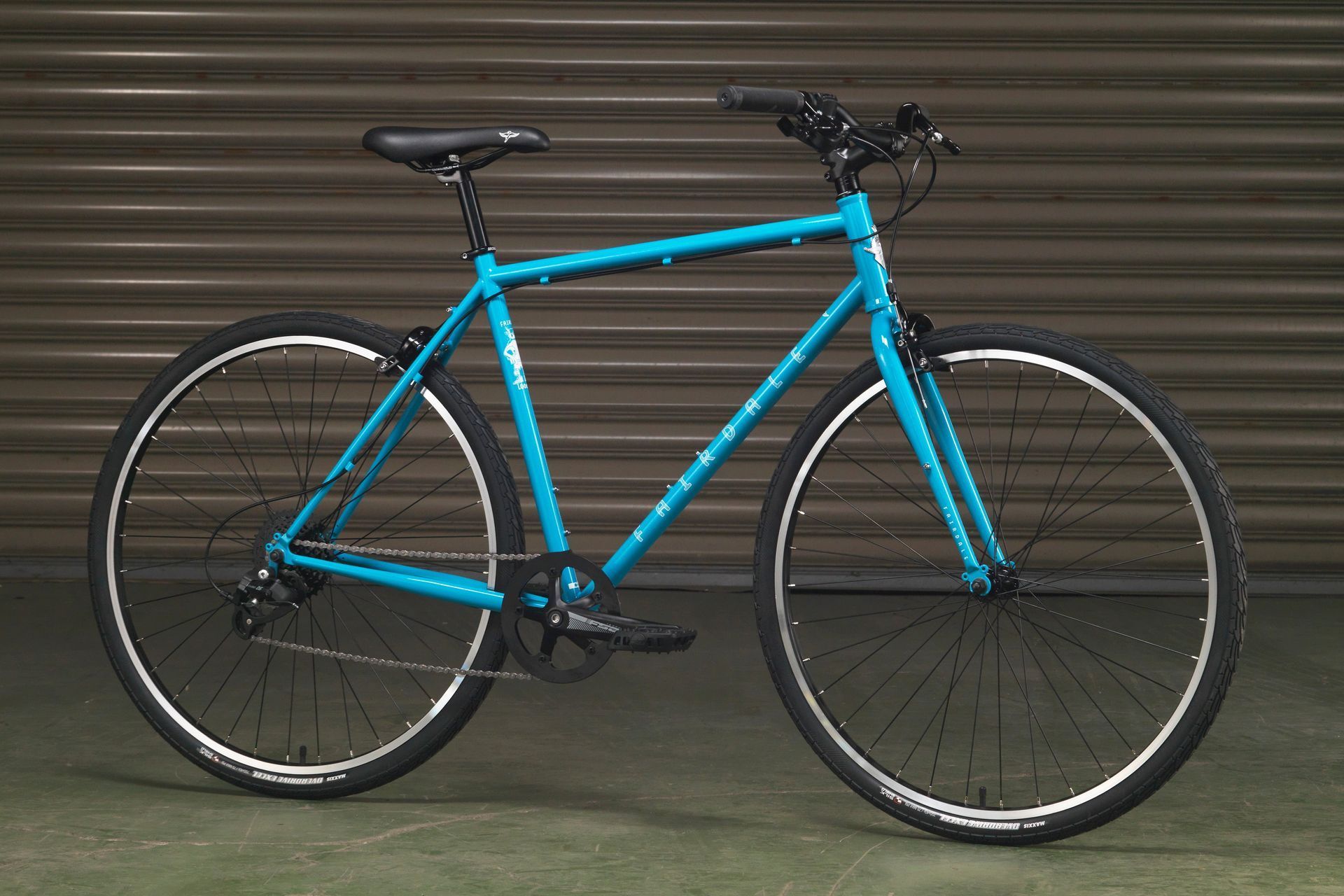 A blue bicycle is parked in front of a garage door