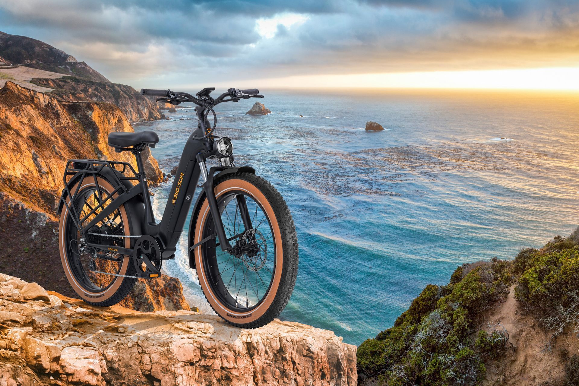 An electric bike is parked on the edge of a cliff overlooking the ocean.