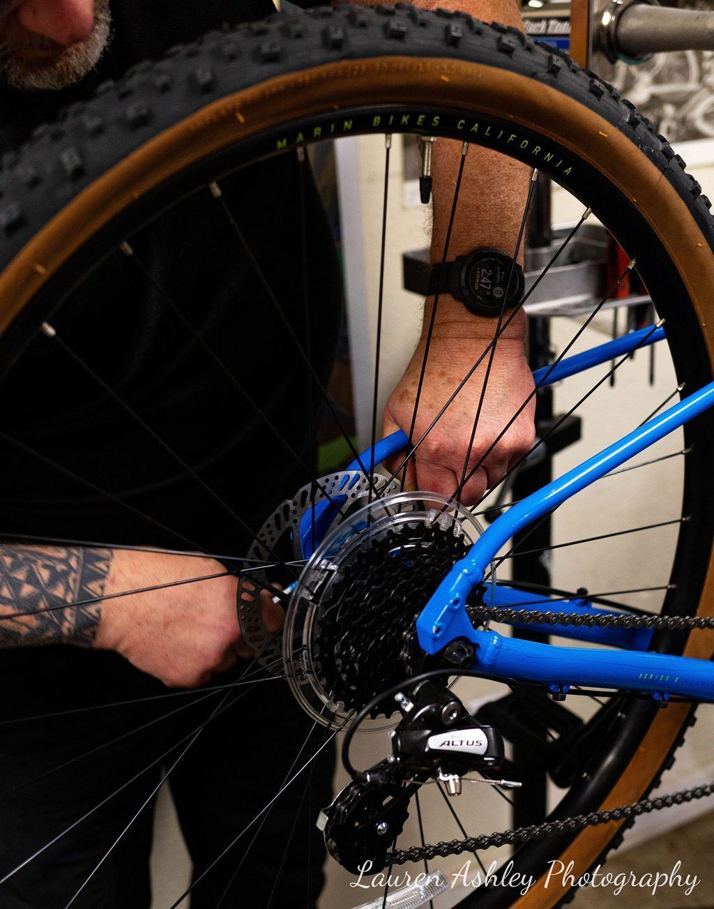 A man is working on a bicycle with a watch on his wrist