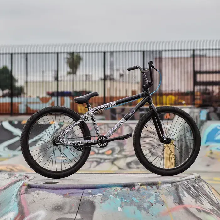 A bmx bike is parked on a ramp in a skate park.