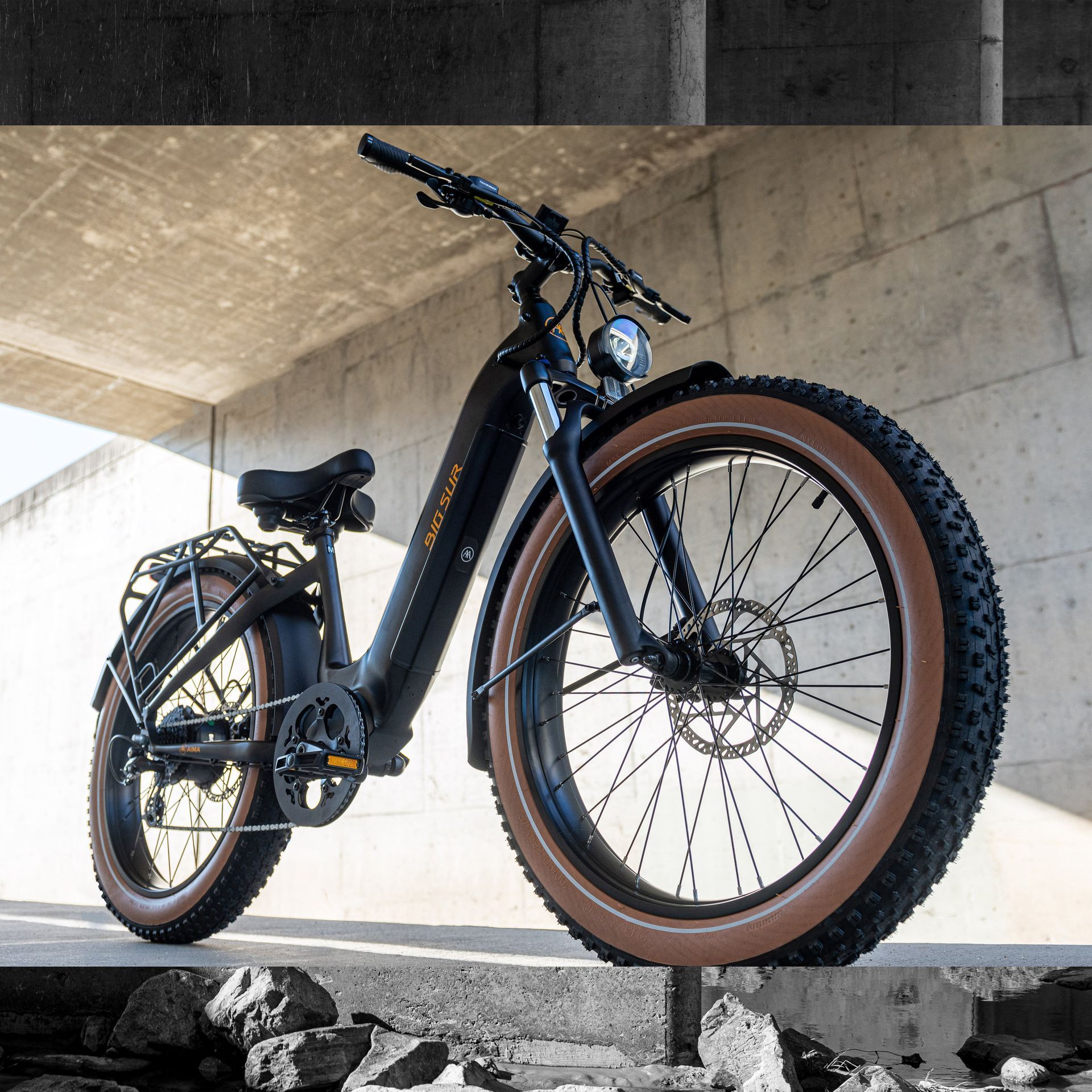 A bicycle with a large tire is parked under a bridge
