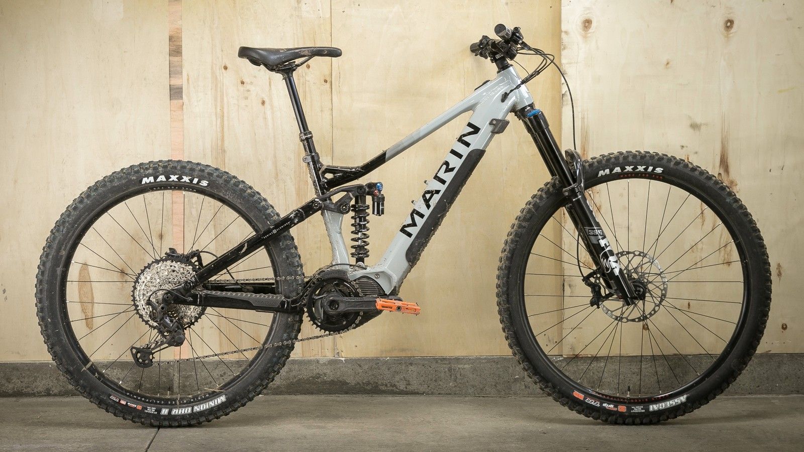 A mountain bike is parked in front of a wooden wall.