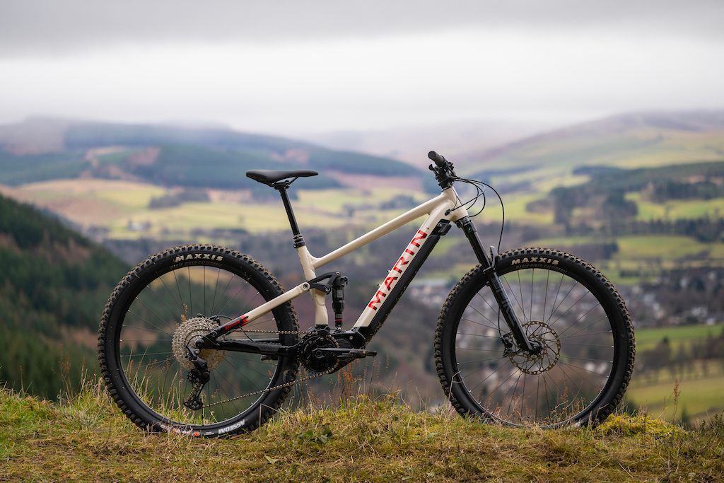 A mountain bike is parked on top of a grassy hill.