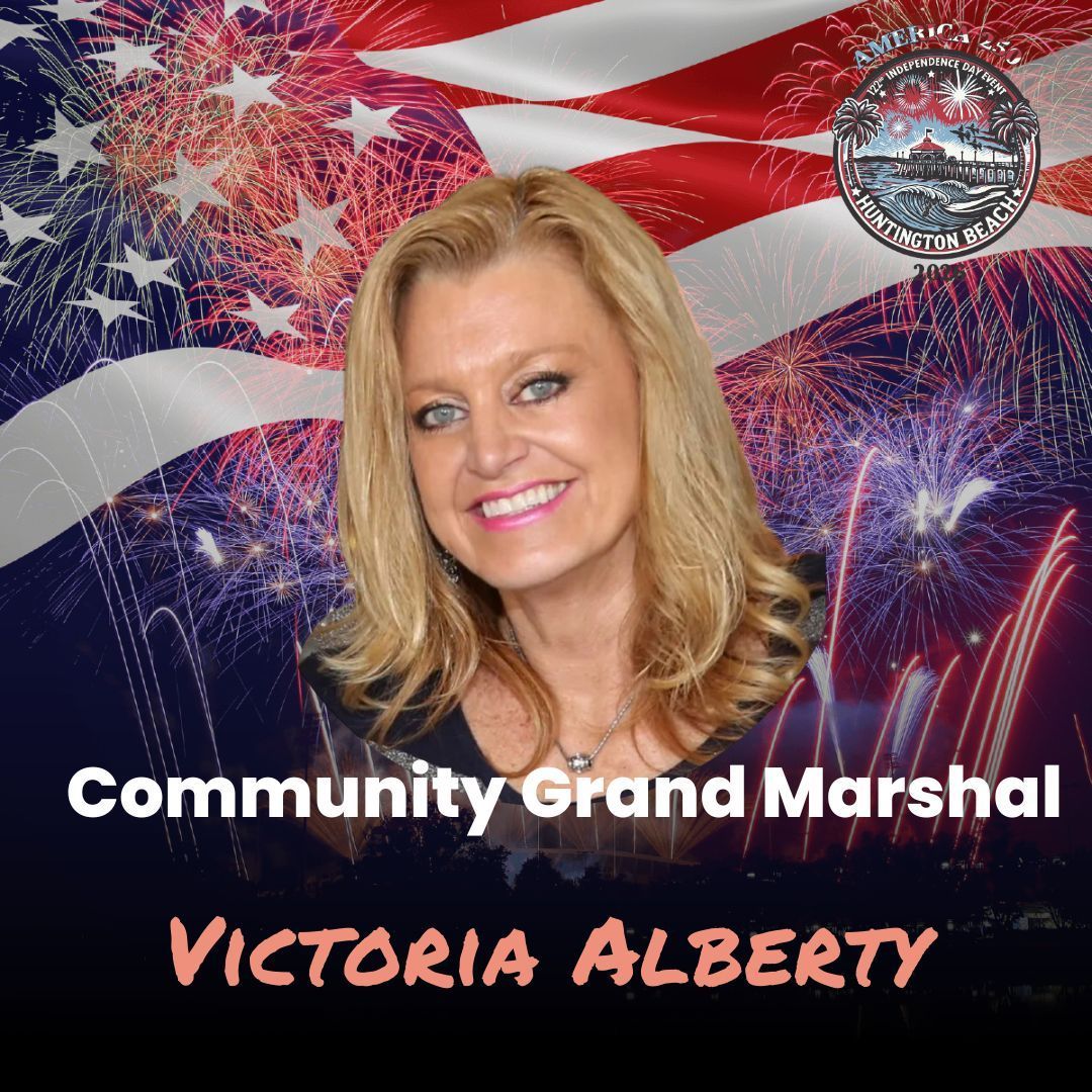 Community Grand Marshal Victoria Alberty smiling in front of fireworks and an American flag backdrop