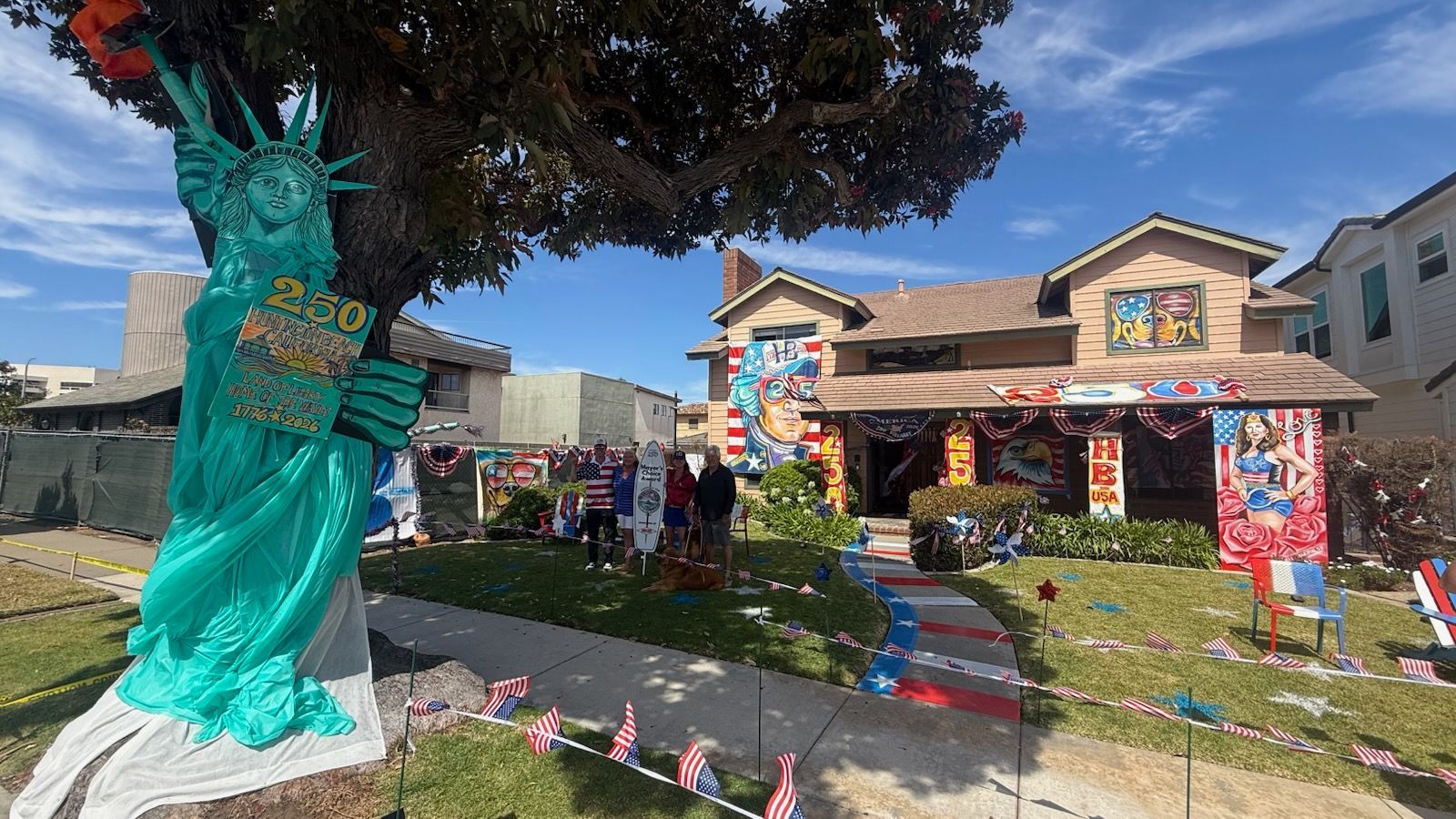 House decorated with colorful banners and lawn figures for a festive event, viewed from the front yard