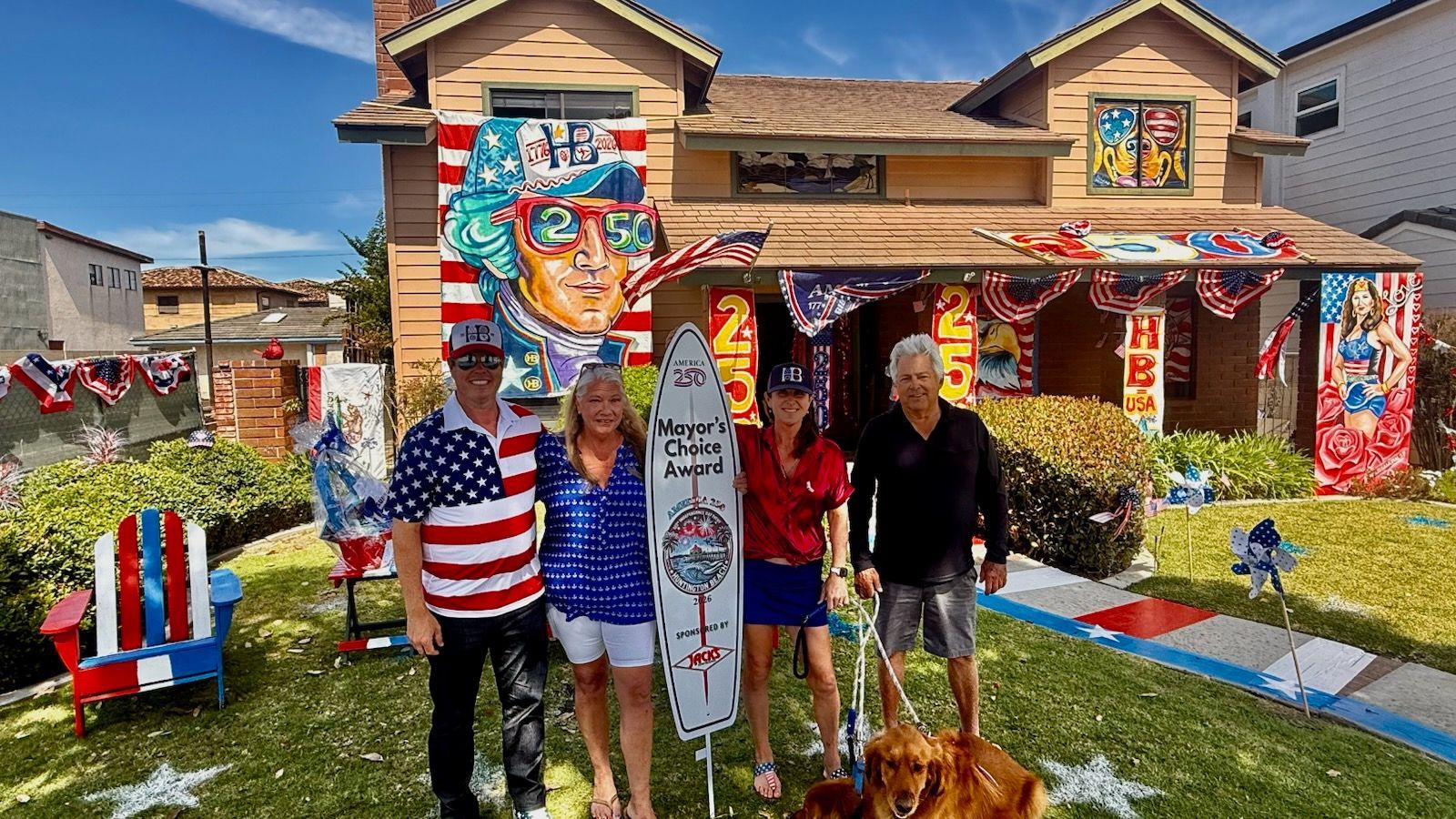 Family posing in front of a house decorated with patriotic red, white, and blue murals and flags.