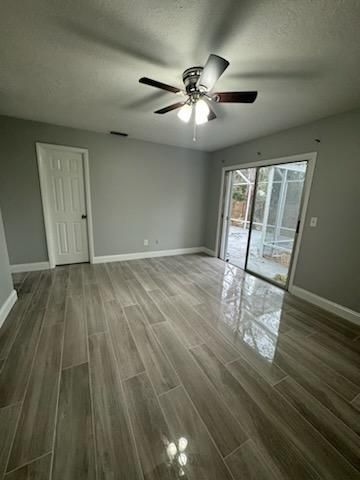 A living room with a ceiling fan and sliding glass doors.