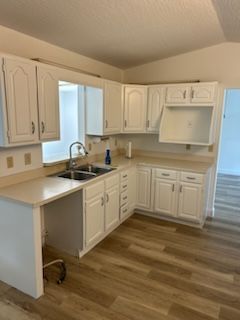 A kitchen with white cabinets and a sink.
