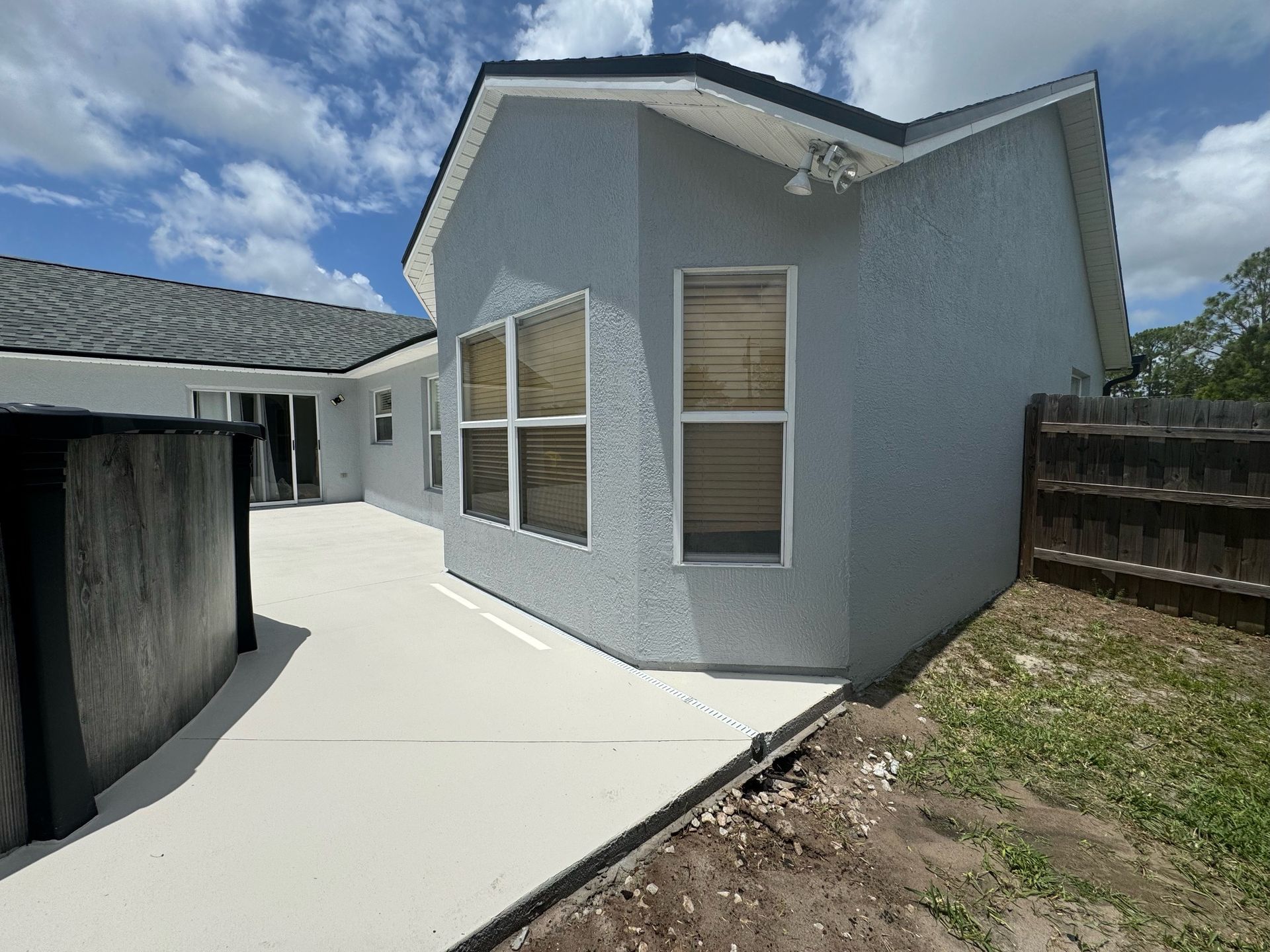 A house with a lot of windows and a fence in the backyard.