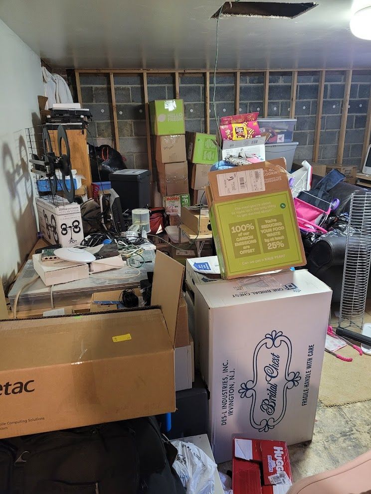 A room filled with lots of boxes and a refrigerator.