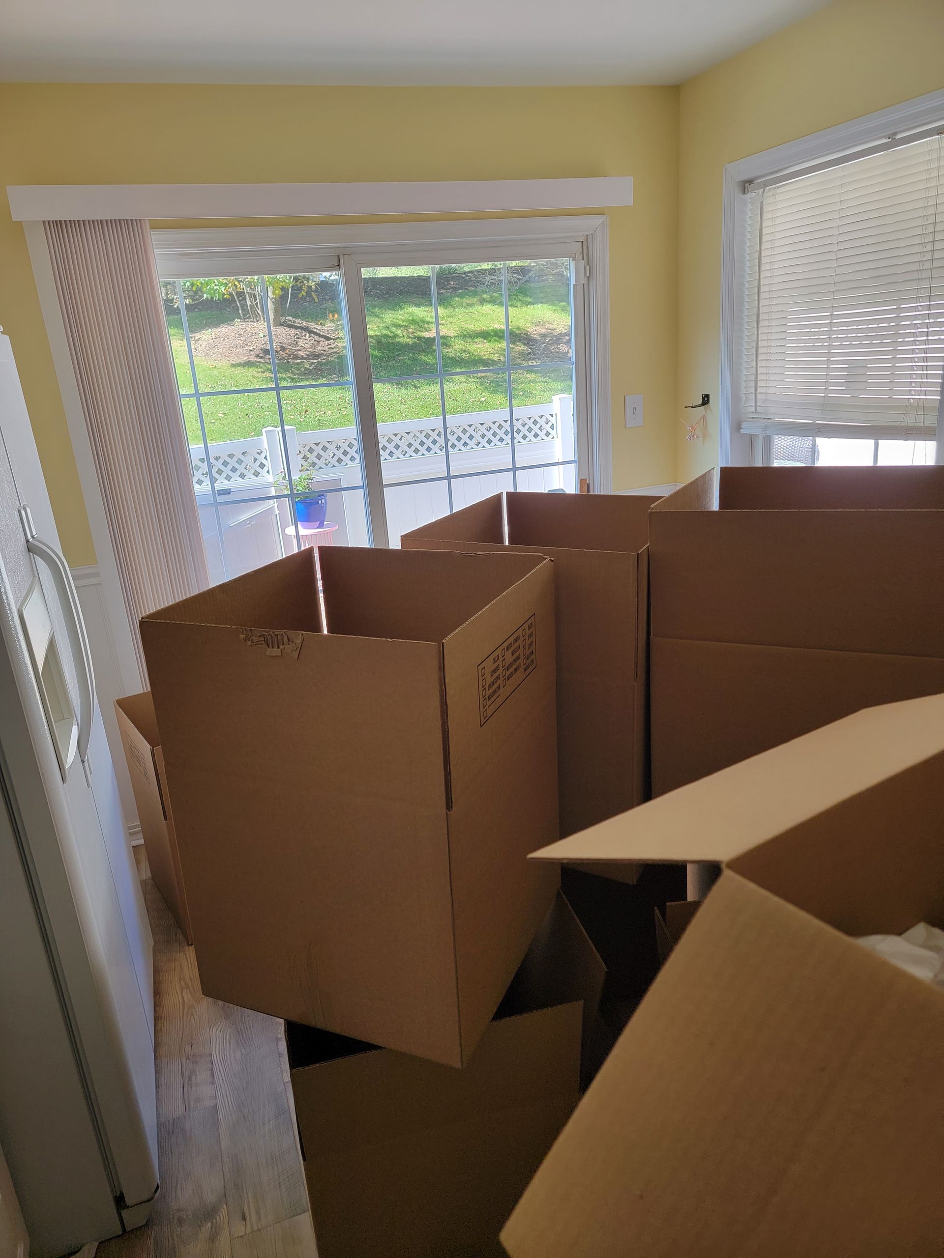 A bunch of cardboard boxes in a room with a window