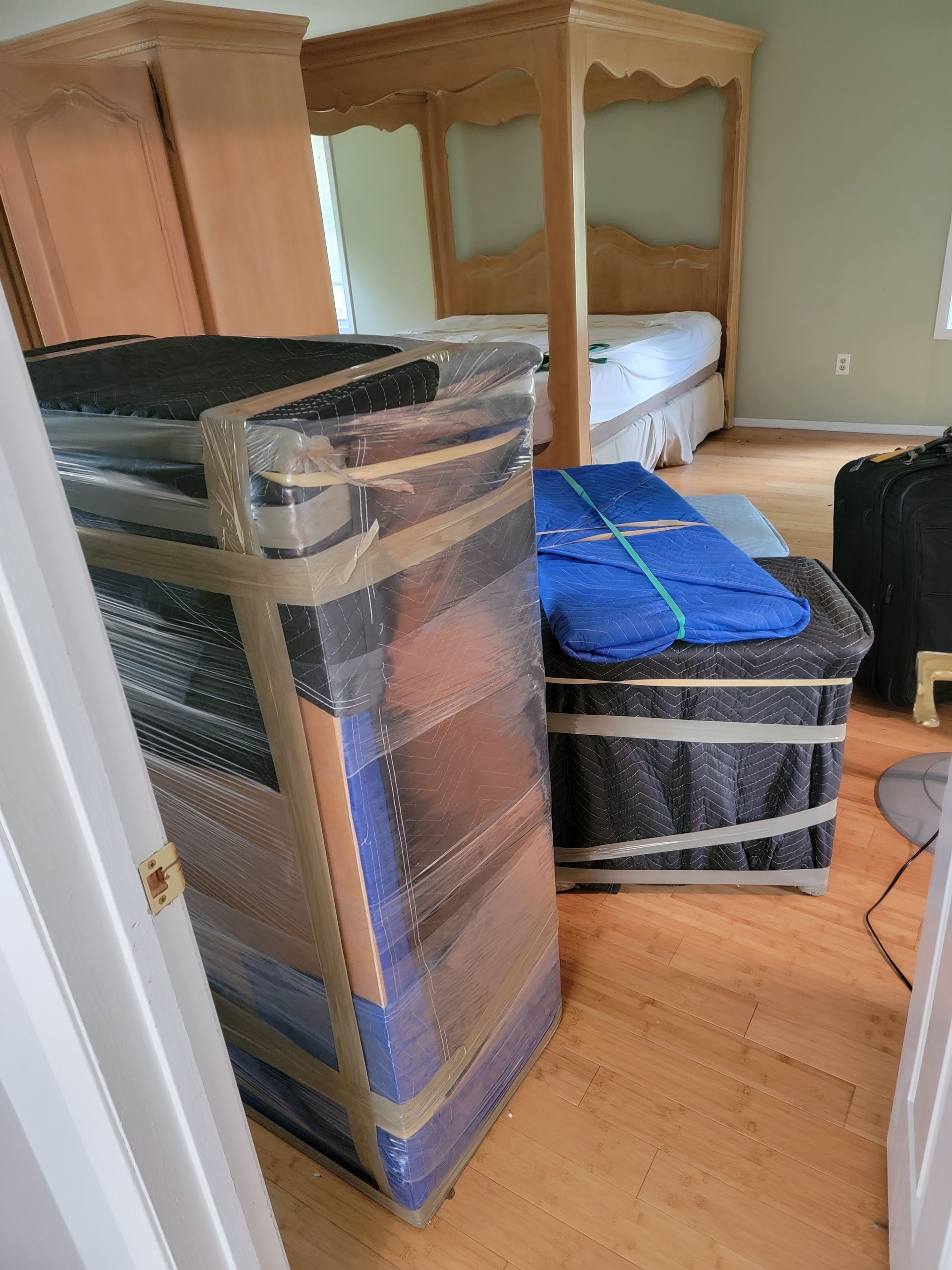 Furniture that has been wrapped in moving pads ready to be carried by movers