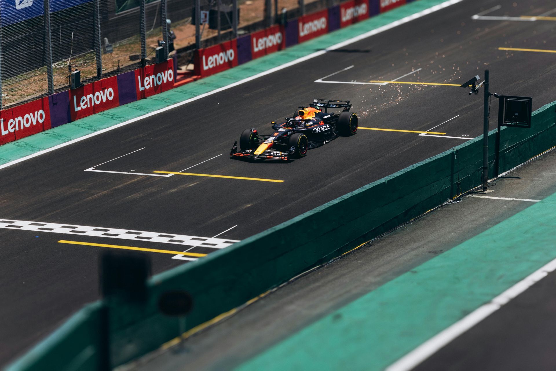 A red bull race car is driving down a race track.