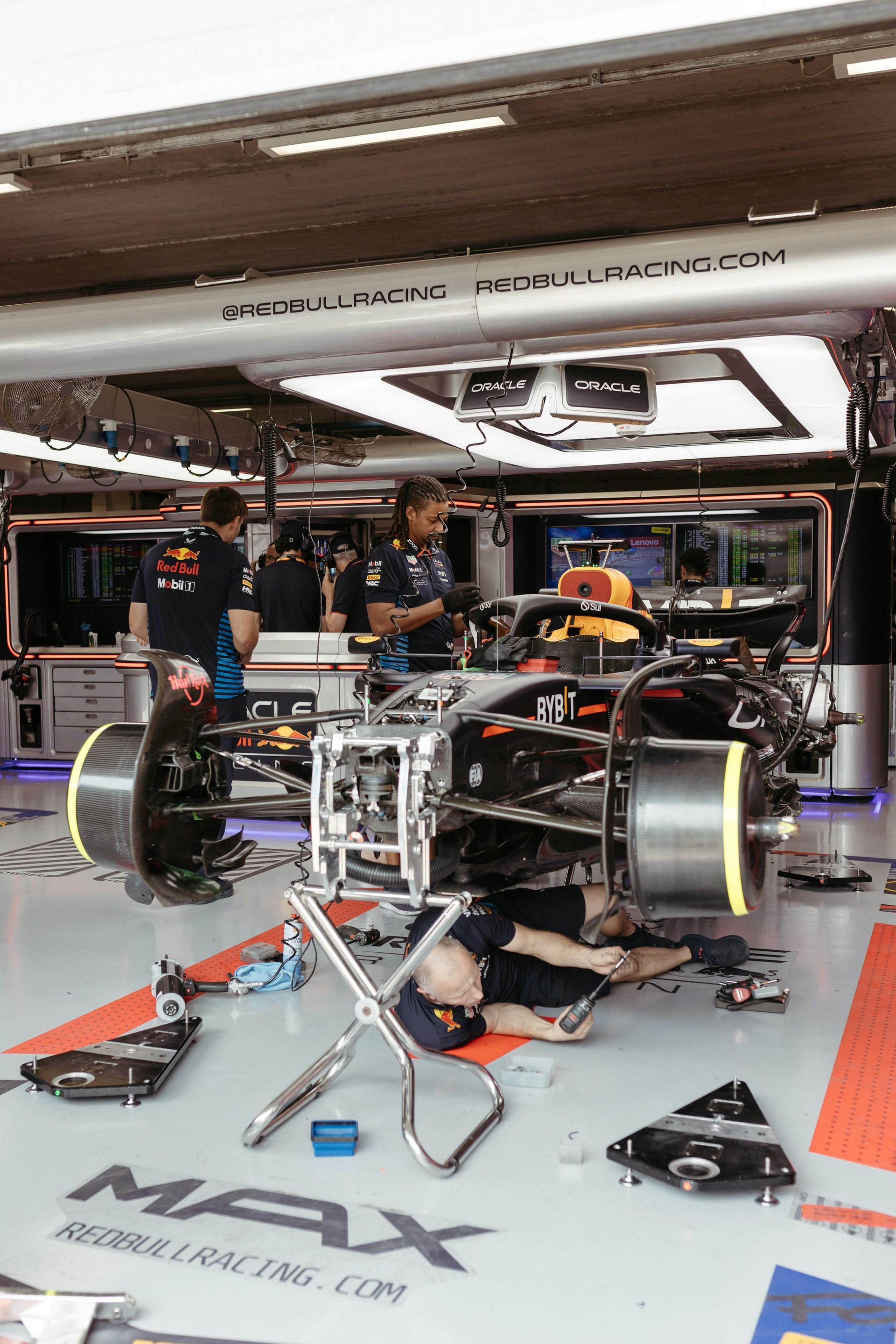 A man is working on a race car in a garage.