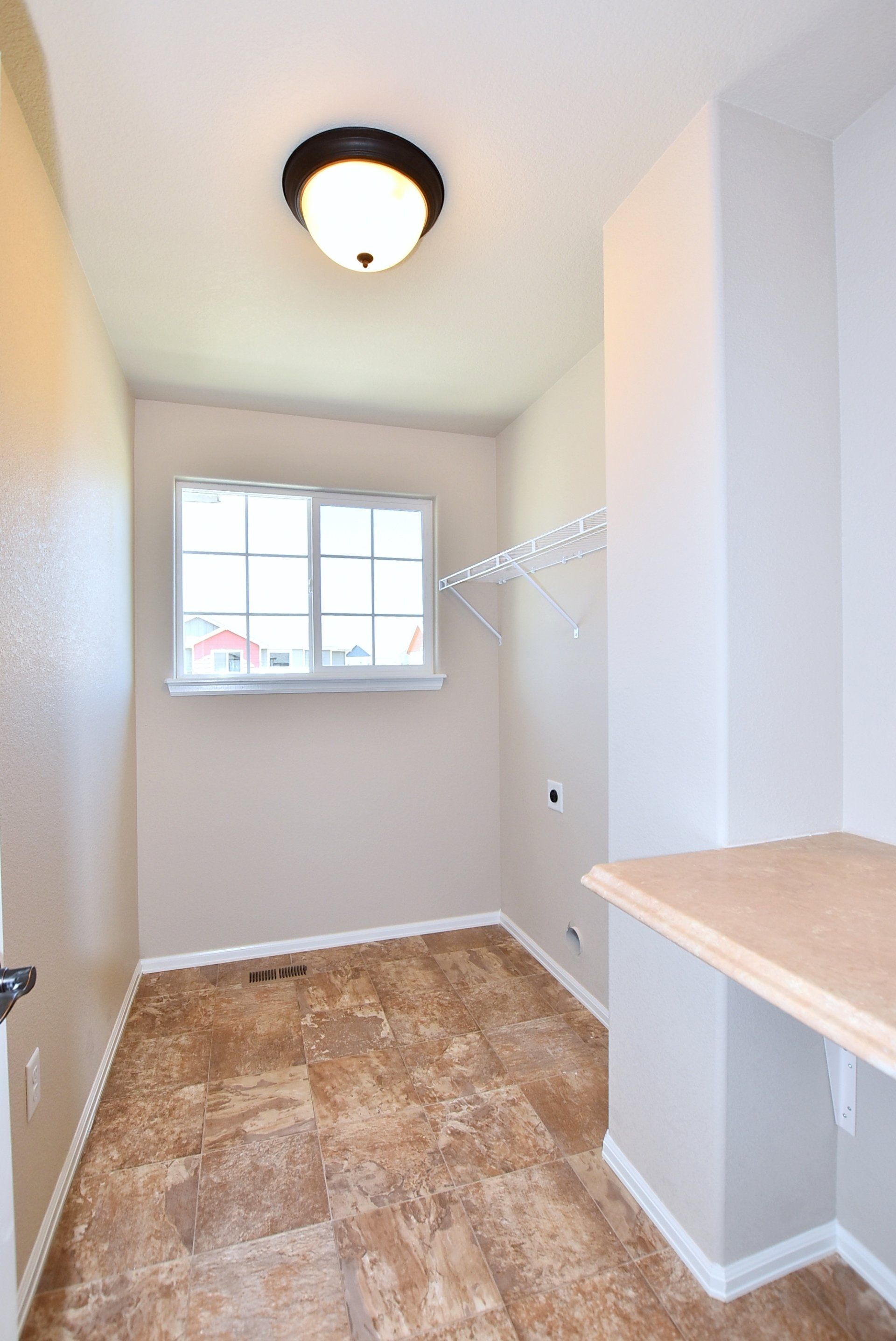 Laundry room with tile flooring and shelf