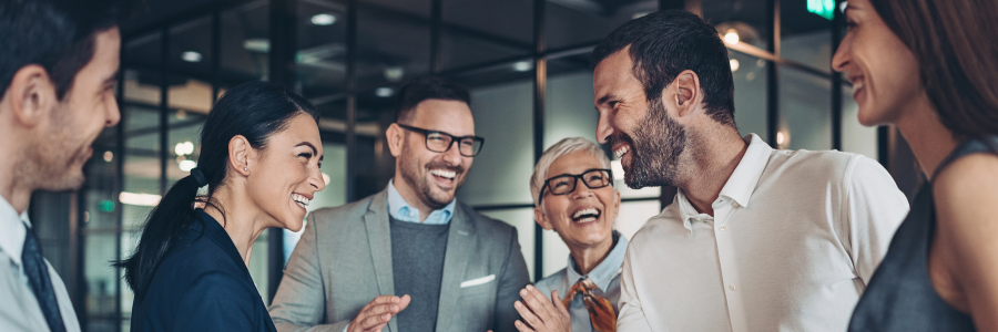 A group of people are standing around talking to each other in an office.