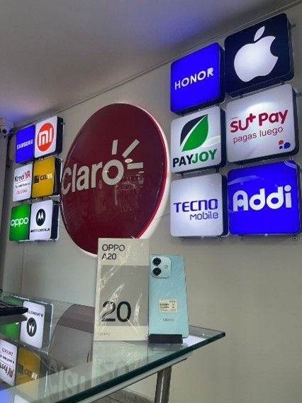 Un teléfono en exhibición frente a un cartel que dice claro