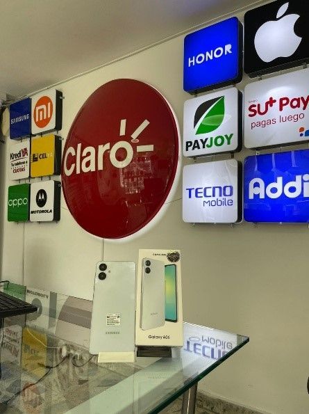 Un teléfono está en exhibición frente a un cartel que dice claro