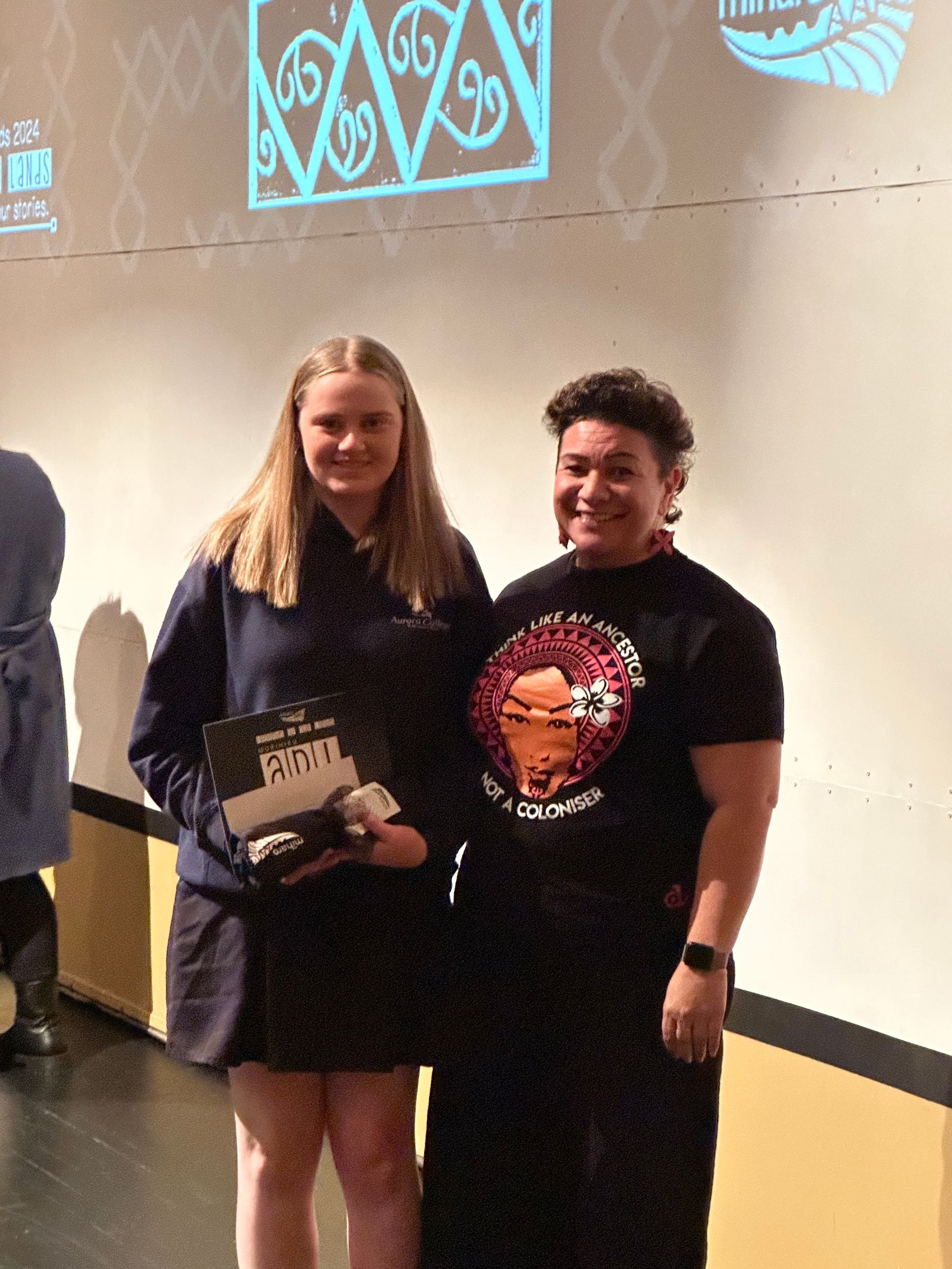 Two people standing next to each other holding a certificate