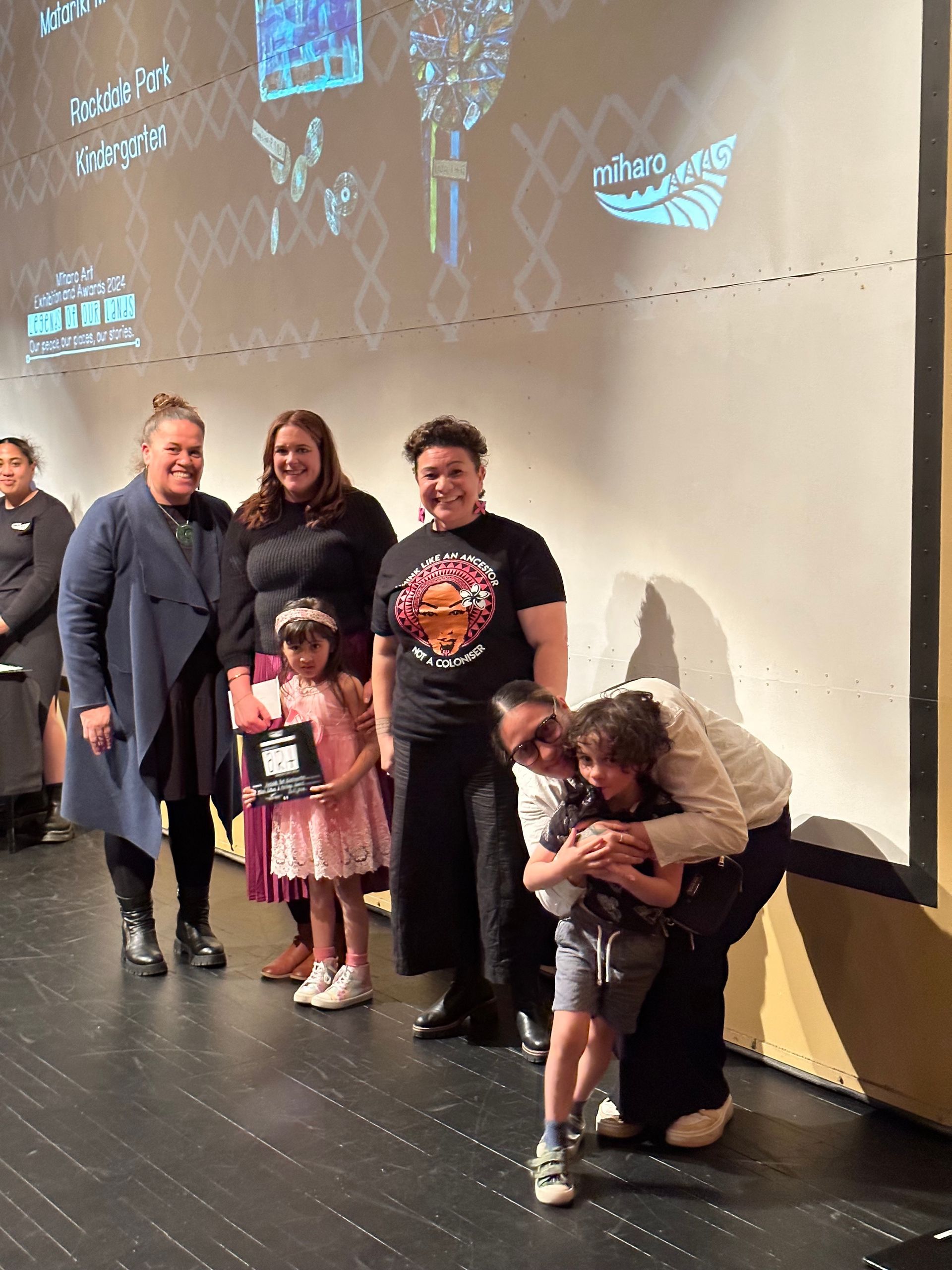 A group of people are posing for a picture on a stage.