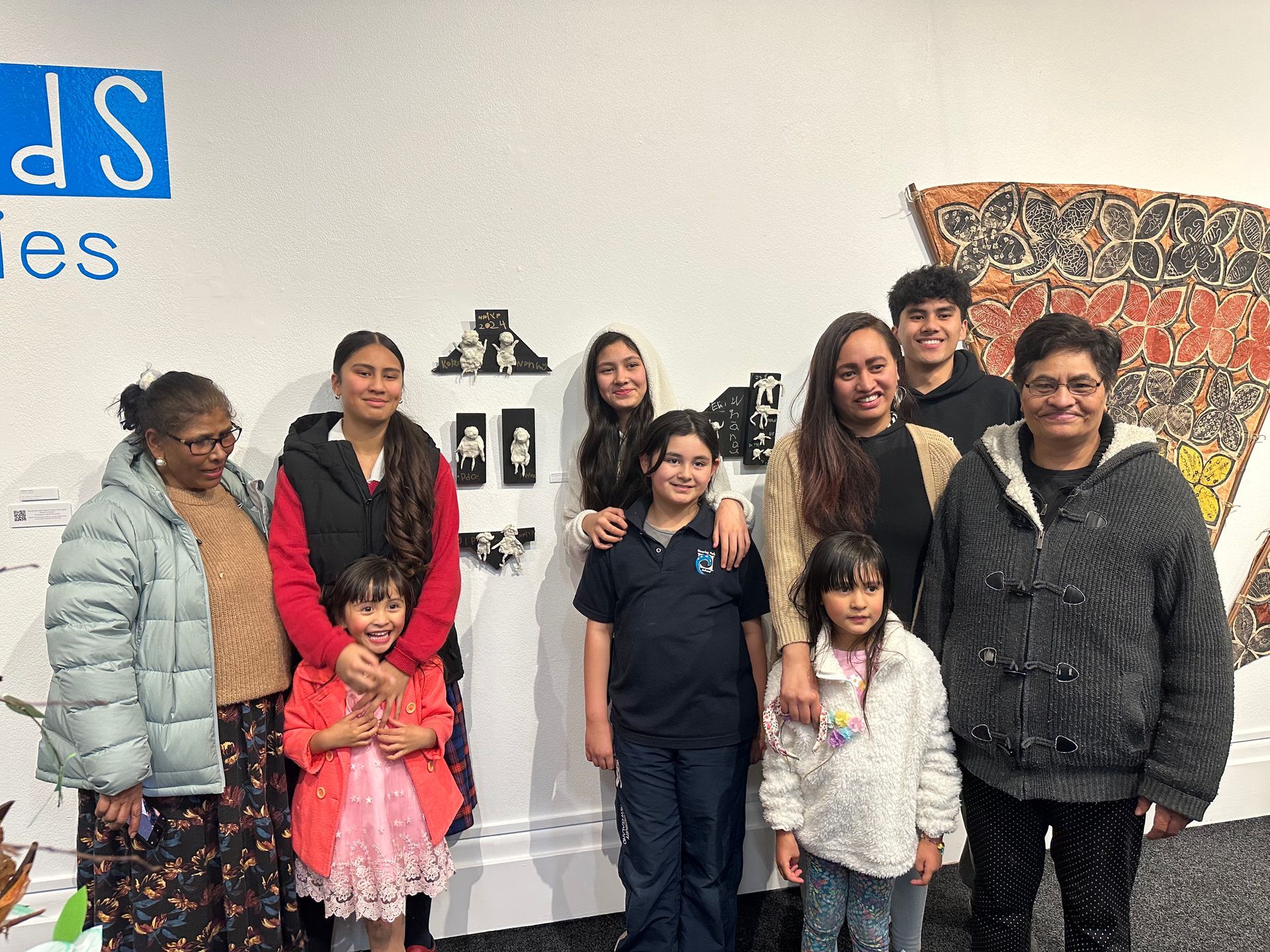 A group of people are posing for a picture in front of a sculpture