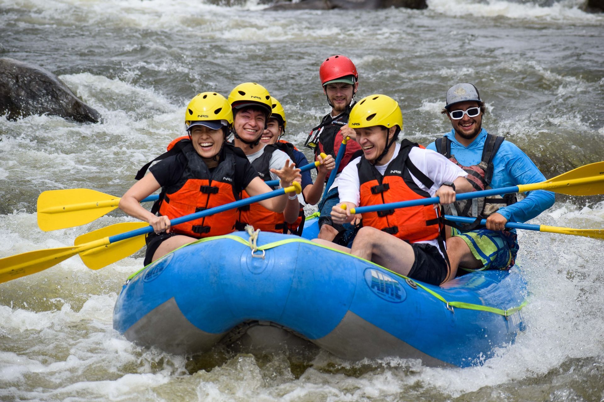A group of people are rafting down a river in a raft.