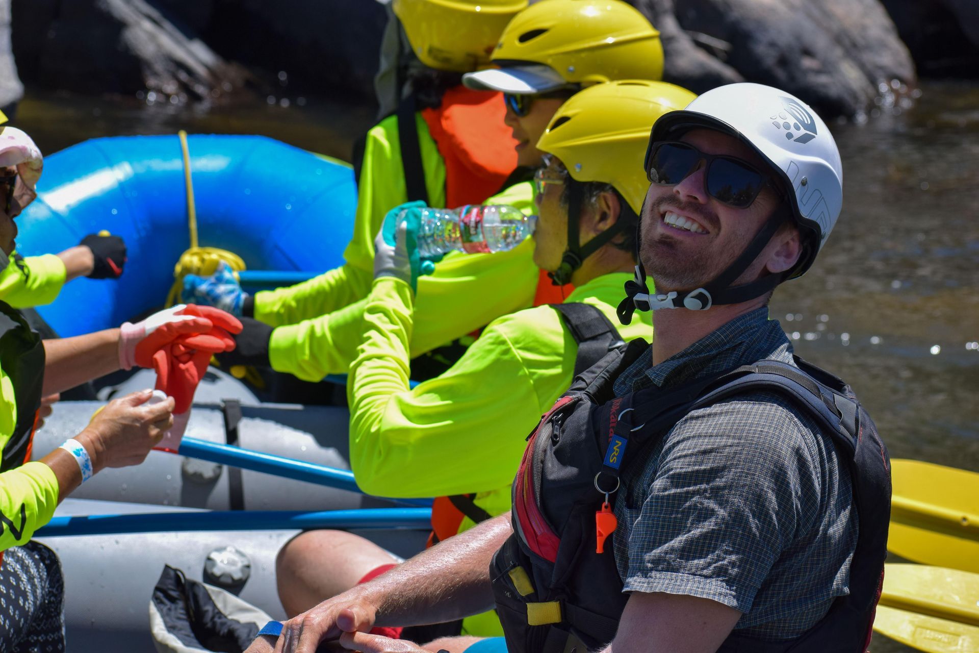 people in a blue raft getting ready to go whitewater rafting